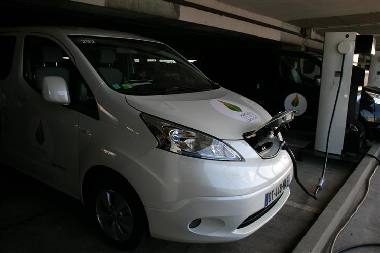 Un Nissan e-NV200 utilisé pour le transport de personnes lors de la COP21 branché sur une borne de recharge rapide