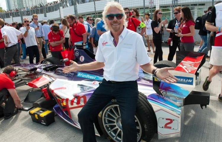Sir Richard Branson assis sur une Formula E appartenant à son écurie Virgin Team
